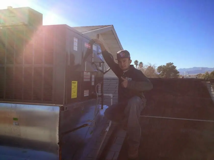 HVAC technician performing Boiler Repair on a rooftop unit in Barbecue