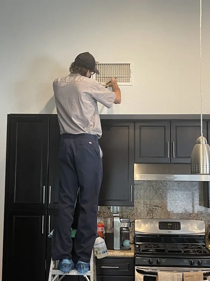 Technician inspecting an air vent during HVAC service in Barbecue
